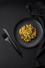 Delicious fusilli pasta with green pesto sauce, with salt and spices
