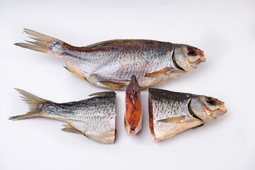 Dried salted river fish with caviar in the section on a white background