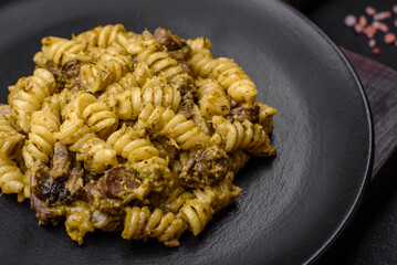 Delicious fusilli pasta with green pesto sauce, with salt and spices