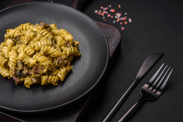 Delicious fusilli pasta with green pesto sauce, with salt and spices