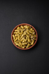 Delicious fusilli pasta with green pesto sauce, with salt and spices