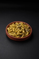 Delicious fusilli pasta with green pesto sauce, with salt and spices