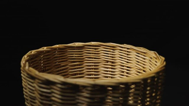Fragment of a basket made of willow twigs or garden furniture. On black background