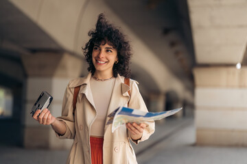 Attractive young Italian woman tourist with short brown curly hair and backpack on her back ready...