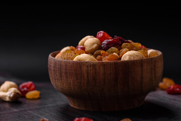 Fototapeta na wymiar Mix of roasted cashews, hazelnuts and walnuts with dried cranberries and raisins