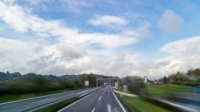 Daytime timelapse of POV traffic on an Austrian alpine highway during autumn. Features mountains, clouds, and the vibrant colors of the season. Ideal for travel and landscape projects.