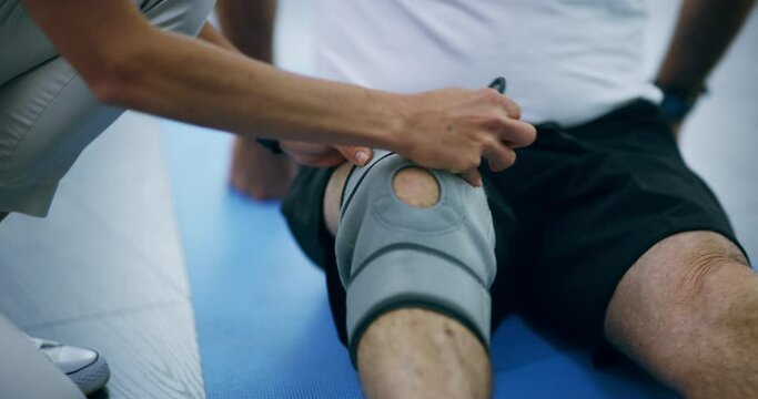 Physiotherapy, training and knee with a bandage after injury, accident or rehabilitation. Help, fitness and hands of a doctor with a brace for leg of a patient for muscle care, recovery and health