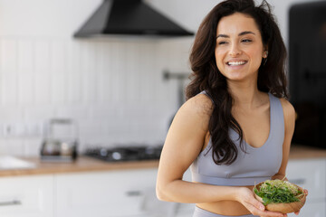 Beautiful smiling woman holding bowl with fresh micro green