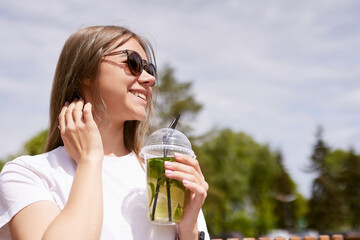 young girl drinking cool matcha cocktail in sunny weather