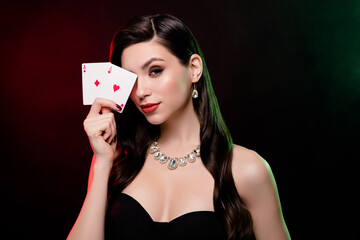 Studio photo stunning woman dealer hold card vip private party poker club poker night neon filters reflect on long hair - obrazy, fototapety, plakaty