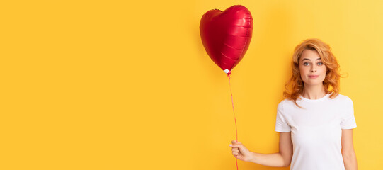 amazed redhead girl with love heart balloon. charity and donation. Beautiful woman isolated face portrait, banner with mock up copy space.