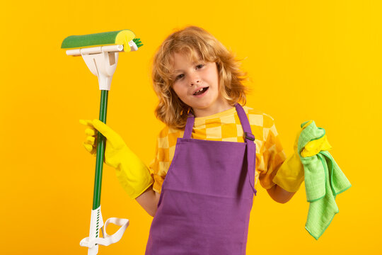 Child cleans at home concept. Kid cleaning with mop to help with housework. Little cute boy sweeping and cleaning, isolated on studio color background.