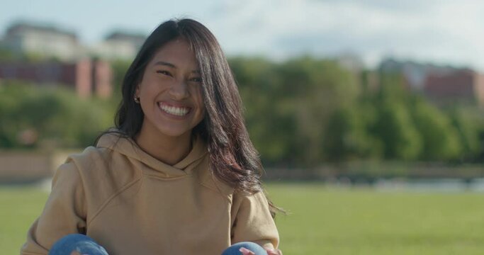 Close-up happy young teen latina college student in a park