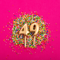 Candle number 49 - Birthday or anniversary on rhodamine red background