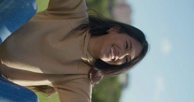 Close-up happy young teen latina college student in a park, vertical shot