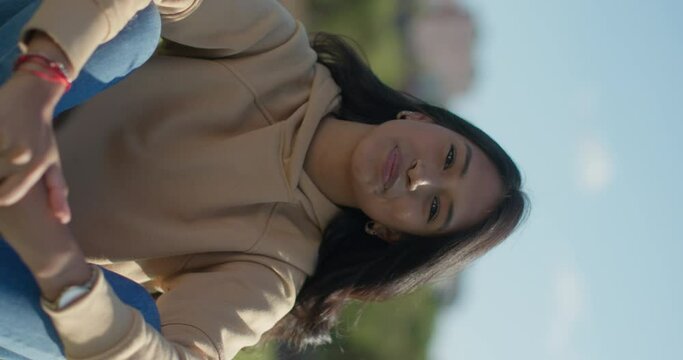 Close-up happy young teen latina college student in a park, vertical shot