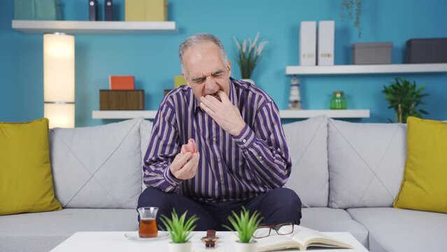 Old man puts his prosthetic dentures in his mouth.