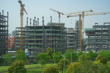 building construction site, hoisting cranes and new multi-store buildings