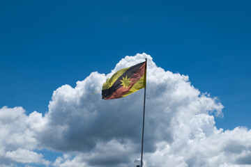 Sarawak flag waving against blue sky, flag of the Sarawak state, East Malaysia