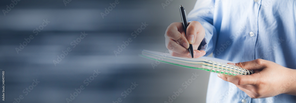 Poster hand writes with a pen in a notebook