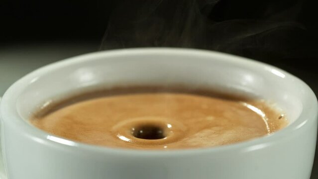 Super slow motion of falling drop into coffee with camera motion. Filmed on high speed cinema camera, 1000fps placed on high speed cine bot. Speed ramp effect.