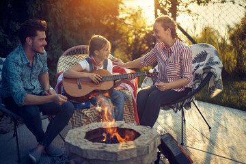 Fototapeta na wymiar Family Fun Around the Campfire: Marshmallows, Music, and Memories