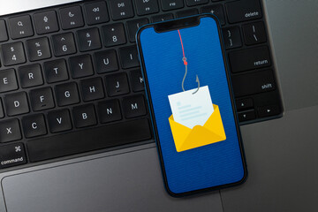 Email Phishing Concept on a Smartphone Screen over a Laptop Keyboard