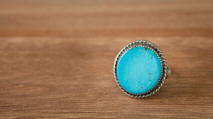 Silver ring whit turquoise gem
 isolate. Copy space on wood background.