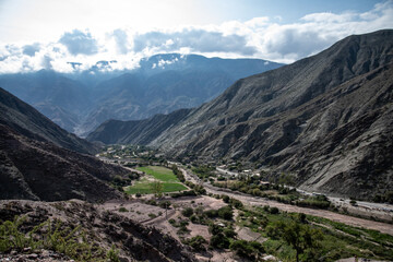 Fototapeta premium Purmamarca, Argentina. Landscape of the entrance to the village between mountains. No people. Daytime, Sky with clouds.
