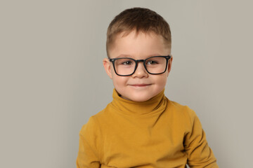 Cute little boy in glasses on light grey background. Space for text - obrazy, fototapety, plakaty