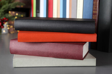Stack of hardcover books on grey table indoors, closeup