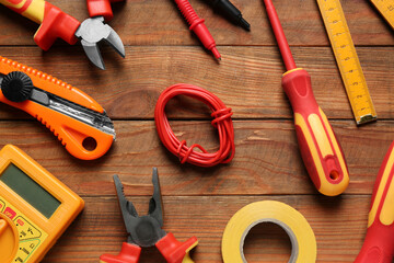 Wire and electrician's tools on wooden table, flat lay