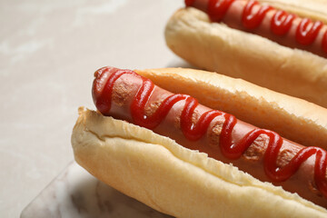 Fresh delicious hot dogs with ketchup on table, closeup