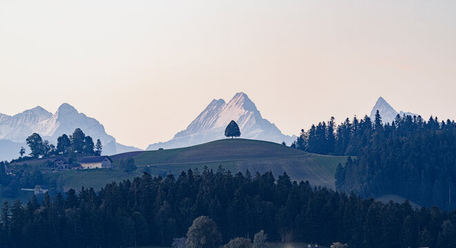Schreckhorn, Wetterhorn, Finsteraarhorn and Eiger mountains view from green rolling hills, Sumiswald, Emmental, Bern, Switzerland