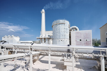 Obraz premium Large manufacturing plant of silica products under blue sky
