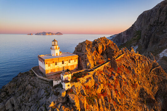 Aerial view of Punta della Guardia lighthouse on top of a cliff on the island of Ponza, lit from sunrise, Ponza island, Pontine islands, Mediterranean Sea, Latium, Lazio, Italy