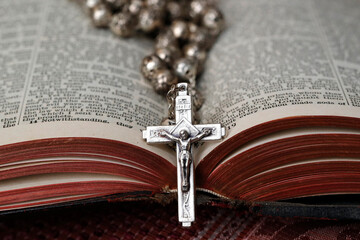 Vintage rosary with crucifix on an open Bible, Christian religious symbol, France