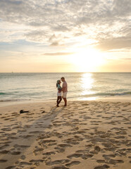 A couple of men and women are on the beach watching the sunset during vacation at Aruba Island Caribbean. mature couple on the beach 