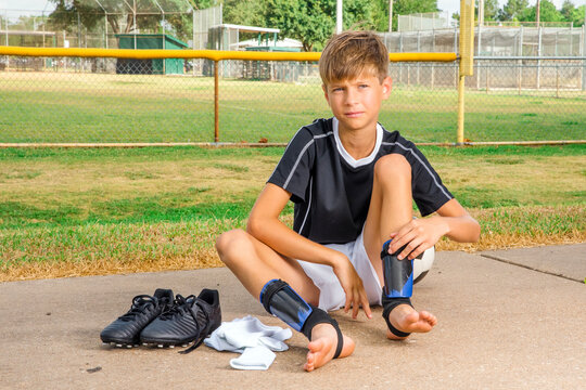 Young male soccer player getting dressed before a game