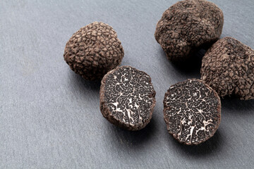 fresh black truffles on a gray slate.