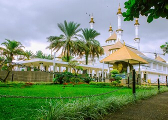 The beauty of the grand white mosque with golden domes and a large garden courtyard in Tasikmalaya, West Java, Indonesia