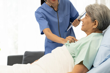 Obraz premium Young female surgeon doctor use stethoscope to check female patient heart beat