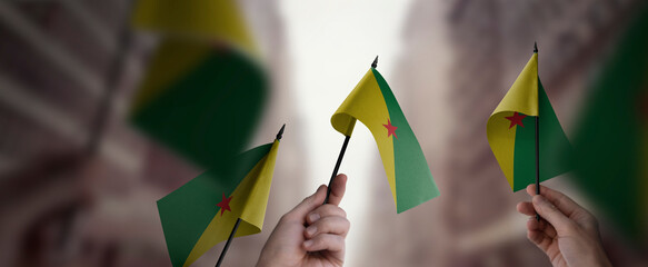 A group of people holding small flags of the French Guiana in their hands