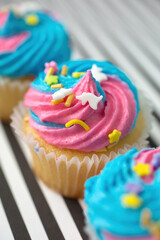 Cupcakes with blue and pink icing on a blue background - 604231637