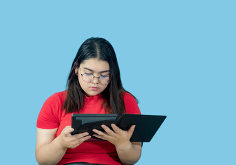 Portrait business girl young woman asian chubby fat cute beautiful pretty one person wearing red shirt in office holding digital tablet and smiling standing with copy space on isolated blue blackgrond