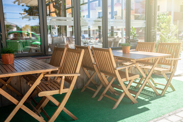 Outdoor cafe with wooden chairs in soft sunlight