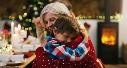 Christmas, love and a grandma hugging her grandchild in the home during the festive season...