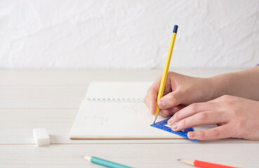 A child writing shapes in notebook. A person who solves math problems. ノートに図形を書く子供。算数の問題を解く人