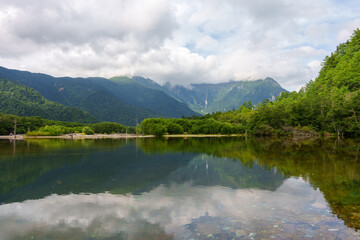 Fototapeta na wymiar 青々とした山と透き通った池　上高地　大正池　穂高連峰