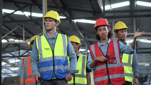 group of diversity Factory asian worker with Industrial Engineer inspector and african manager walking visit and checking mechanical in Manufacturing Facility teamwork meeting training and discussion
